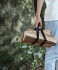 Person carrying firewood secured with 4 Pack Heavy Duty Luggage Tie Straps Featuring Swivel Hog Ring Hooks For Roof Rack Cargo And Truck Bed Hauling Secure Your Gear With Zero Sweat On Long Drives.