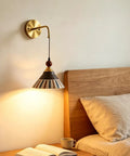 DWEIHDV Ceramic Wall Sconce Vintage Gold Wall Light Fixture above a wooden bed, showcasing a hand-painted striped ceramic shade.