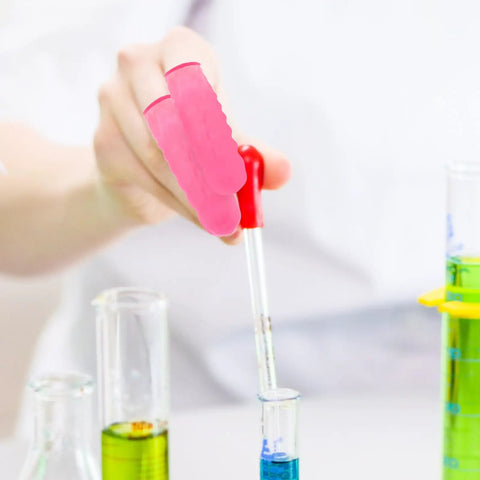 Person using Premium Latex Finger Cots 100 Pack Anti Static Breathable Protective Covers while handling a dropper over test tubes.