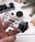 Close-up of a clear container with a black lid from the 50 Pack Silicone Rubber Hole Plugs Set With 6 Sizes T Type Stoppers