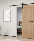 Interior view of 6.6ft Sliding Barn Door Hardware Kit with heavy duty steel rollers and flat tracks, installed on a wooden door.