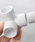 Close-up of 3-Way PVC Pipe Fittings Half Inch White SCH40 Furniture Grade Tee Elbow Corner Connectors held by hand