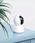 360 Degree All-In-One Home Security Cam 2K With AI Human Detection, 360 Pan, 108 Tilt, white cam on blue table with plant