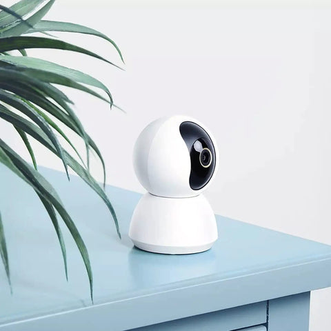 360 Degree All-In-One Home Security Cam 2K With AI Human Detection, 360 Pan, 108 Tilt, white cam on blue table with plant