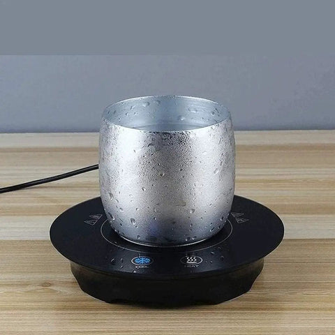Fast Acting USB Mug Warmer With Smart Adjustable Heat Control Keeps Your Morning Sip Piping Hot All Day Long Sleek Black Tempered Glass Platform with a silver mug.