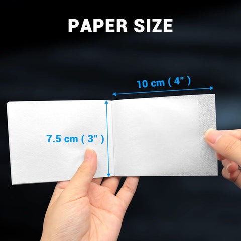 Lens cleaning tissue paper booklet, open to show white sheets and 7.5 cm by 10 cm pages