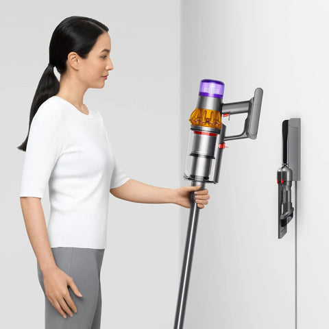 Woman using V15 Detect Total Clean Extra Refurbished Premium Vacuum Cleaner With Laser Dust Detection on white wall mount