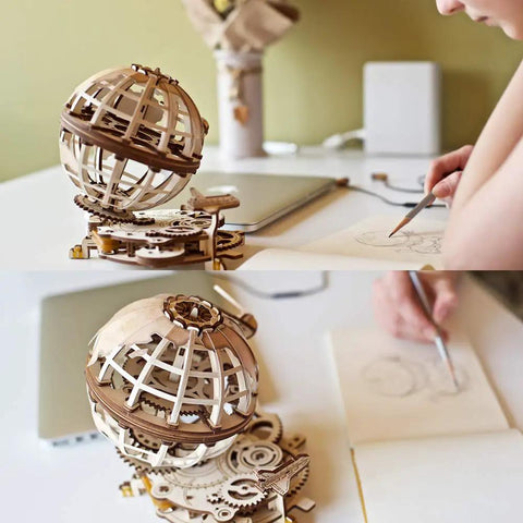 Three Dimensional Wooden Globe Puzzle Kit For Adults, Mechanical World Model, Brain Teaser And Educational Globe Build Set, DIY Wooden Globe Craft Hobby For Adults To Build And Show Off. Wooden globe puzzle on desk beside sketching hand