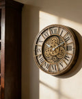 18 Inch Moving Gears Wall Clock Oversized Industrial Steampunk Design With Antique Oil Rubbed Bronze Finish on wall with vintage books.