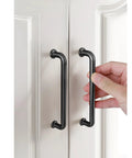 Hand holding 5 Pack 5 Inch Matte Black Kitchen Cabinet Handles And Modern Cabinet Pulls For Cabinets Cupboards Dressers And Drawer Pulls