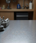 Heavy Duty Stainless Steel Split Lock Washers M6 300 Piece Pack displayed on a metal workbench with a blurred background.