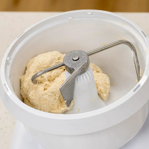 Heavy Duty Stand Mixer 500W Powerhouse With 6.5 Quart Bowl And Wire Whips And NutriMill Dough Hook Extender Bundle For Effortless Mixing Smooth Creations And Bake Ready Results kneading dough in a white bowl