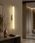 JCQASRT 19.69 in Modern Wall Sconce, 3-Color Changing LED Wall Light Fixture, hardwired brass wall lamp illuminating a hallway.