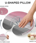 Hand pressing U Shaped Memory Foam Travel Neck Pillow With Pink Wood Grain Finish showing features like zipper and fabric cover