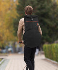 Heavy Duty 12 Inch Practice Pad Backpack That Stays Totes Waterproof And Shields All Your Drum Gear securely on a person outdoors.