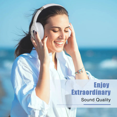 Woman wearing Over Ear Bluetooth Headphones With 65 Hour Battery Life, enjoying music by the sea