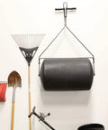 Powerful 270 Lb Poly Lawn Roller For Push Or Tow with easy turn tethered plug hanging next to garden tools