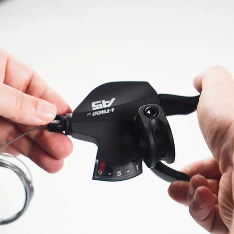 Close-up of right hand 9 speed trigger shifter lever for Shimano and SRAM bikes thumb button upshift and downshift mechanism.