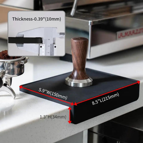 Espresso Tamping Mat For Baristas Grippy Black Food Grade Silicone Pad 8 Inch By 6 Inch Waterproof And Heat Resistant Portafilter Mat For Espresso Machines And Home Brewing Accessory in use next to espresso machine showing measurements and tamper.