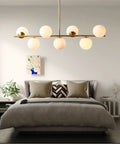 Groovy Mid Century Modern Pendant Light Set Featuring Sleek Glass Globes and Gold Finish over a stylish bed and decor.