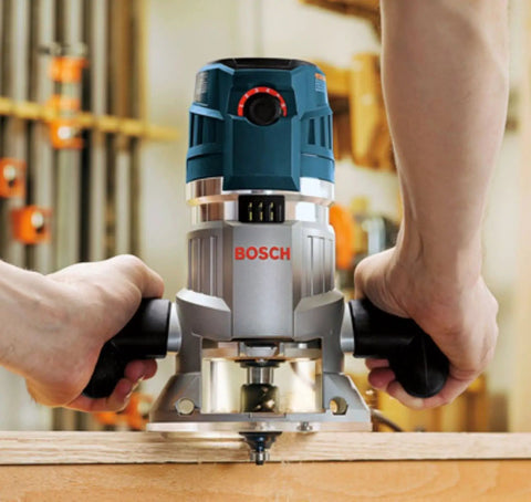 Hand holding a router using the Six Piece Universal Groove Cutter Router Bit Set With Carbide Tips For Soft And Hard Wood And Wood Composites Built Tough For Precise Finishing And Decorative Grooving on wood surface.