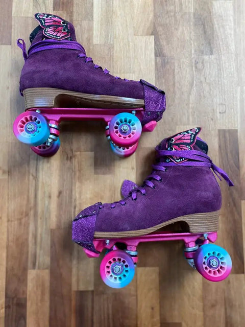 Purple roller skates with pink wheels, featuring butterfly designs and Lickety Splits Roller Skate Bearings 16 Pack For Quad Skates ABEC 9