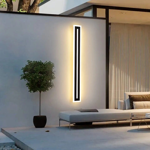 Modern Outdoor Wall Light Sconce 24W LED Exterior Lighting Fixture Waterproof 35.4 Inch Long Ideal For Garage Porch Patio Gates Durable Sconce Wall Lighting For Outdoor Walls. Black finish, mounted on exterior wall next to patio furniture.