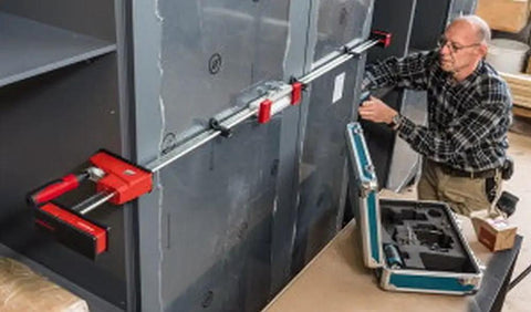Top Shelf K Body Revo Clamp Kit Including Two 24 And Two 50 Inch F Clamps With Quick Slide Wideners in use on cabinetry.