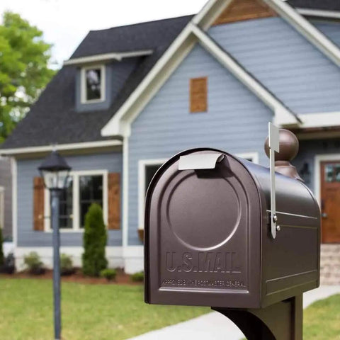 Northpointe Large Capacity Post Mount Mailbox in galvanized steel with Venetian Bronze finish in front of a suburban home