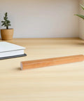 Poster Storage Tube With Caps For Docs And Artwork on a wooden desk, cylindrical and impact resistant for safe document storage.