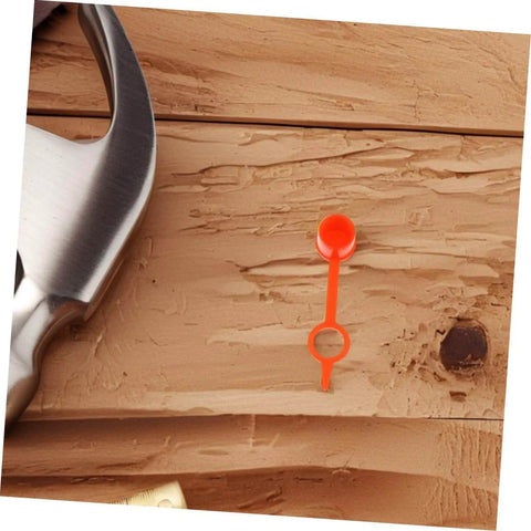 Close-up of a red plastic cap from 200Pcs Butter Mouth Cap Grease Extension Fitting Caps And Nozzles Kit on wooden surface.