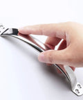 Hand holding round tube stainless steel cabinet drawer handle for doors and cutting boards dope rustproof kitchen hardware