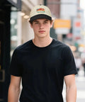 Man wearing RV Pilot Vibes Camper Road Trip Trucker Hat For Adventure Lovers Adjustable Back Buckle Cap in street setting.