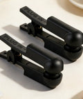 One Pair Black Rubber Ear Clip Electrode For TENS 7000 And Most Standard Units close-up view on a beige background