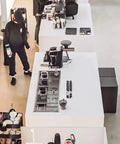 Dang Solid Stainless Steel Bar Glass Rinser With Integrated Drain Tray For Quick Cup Washing In Home Kitchens And Local Pubs Slick Design And Zero Hassle Setup in a busy cafe setting with bar counters.