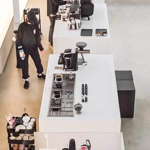 Dang Solid Stainless Steel Bar Glass Rinser With Integrated Drain Tray For Quick Cup Washing In Home Kitchens And Local Pubs Slick Design And Zero Hassle Setup in a busy cafe setting with bar counters.