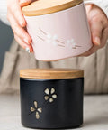 Matte Black Ceramic Coffee Canister With Premium Airtight Seal Keeps Your Daily Grind Fresh No Fuss Wide Mouth Design For Easy Scooping And Reliable Kitchen Pantry Storage with decorative flower design.