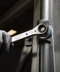 Ratcheting Box Wrench Set SAE One Quarter Inch To Three Fourth Inch Five Piece Kit with a hand using on a pipe, close-up view