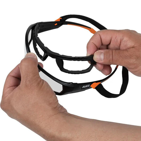 Hands demonstrating Pro Full-Frame Safety Glasses With Removable Gasket, ANSI Z87.1 Plus, with clear lenses and strap.