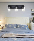 Modern 3 Light Vanity Light Fixture in Black With Clear Glass Shades for Bathroom Wall above bed in bedroom setting