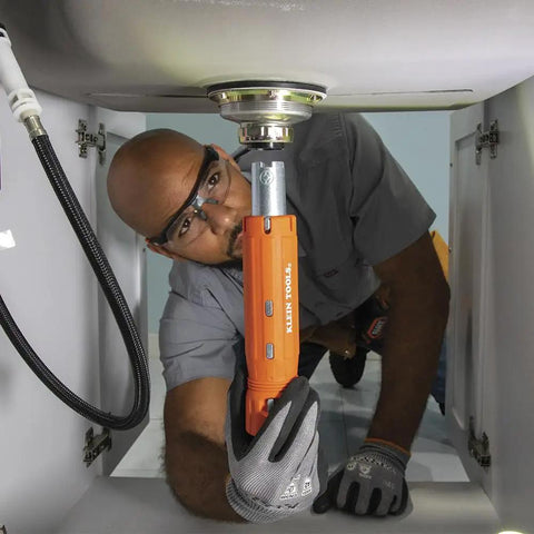 Person using the 12 In 1 Faucet And Plumbing Multi Tool For Sink Toilet And Faucet Installations And Repairs with Tab Mount Wrench under sink