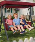 Children enjoying Outdoor Porch Swing Glider With Adjustable Canopy And Weather Resistant Steel Frame in garden on a sunny day