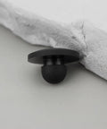 Close-up of a single black rubber foot push in knurled bumper for 1/4 inch holes, part of 100x Rubber Feet Push In Knurled Bumpers For 1/4 Inch Holes, No Tools Needed Press Fit, No Mess Snap In For Furniture Cabinets Electronics Enclosures And DIY Projects, Protect Floors, Reduce Vibration, Durable Non Slip Bumpers.