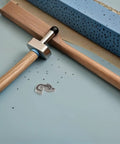 Essential Black Plastic Refrigerator Door Stopper Clip For Modern Kitchens With Universal Compatibility And Secure Closure To Keep Freezer Doors From Slaming Shut Everyday, resting on a wooden surface with tools.