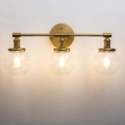 Three Light Vintage Industrial Bathroom Vanity Wall Sconce With Handblown Clear Glass Globes And Antique Gold Finish, 25.2 Inch Wide Triple Light Bath Fixture For A Soft Industrial Look