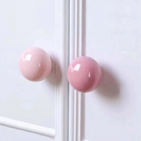 Totally Fresh Ceramic Ball Cabinet Knob Lemon Yellow Single Hole Drawer Pull For Bedroom Dresser And Kitchen Cupboard Lowkey Perfect Hardware Upgrade That Hits Different close-up of pink ceramic knobs on white cabinetry.