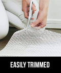 Person trimming Extra Strong Rug Pad Gripper 2x4 Ft for Hardwood Floors and Carpets, slip resistant, dual sided grip pad with scissors.