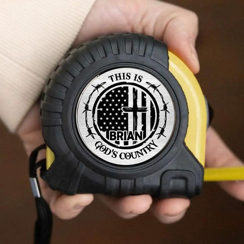 Solid Build Personalized Tape Measure For Woodworking And DIY Projects Featuring This Is Gods Country Engraving in hand.