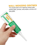 Hand holding tube of Wall Repair Paste Set With Self Adhesive Mending Cream, Scraper And Spout For Quick Crack Fix