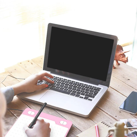 Person using Game Changing Graphics Drawing Tablet With 8192 Pressure Levels And A Dope Battery Free Pen at a laptop on a wooden desk.